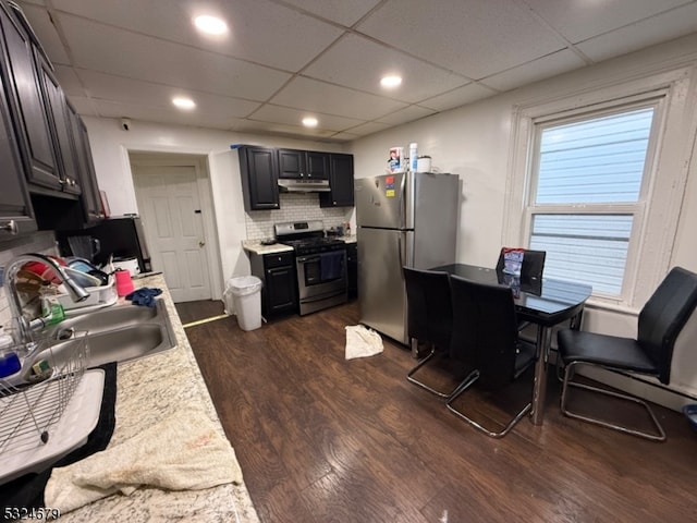 kitchen featuring a drop ceiling, backsplash, dark wood-type flooring, sink, and appliances with stainless steel finishes