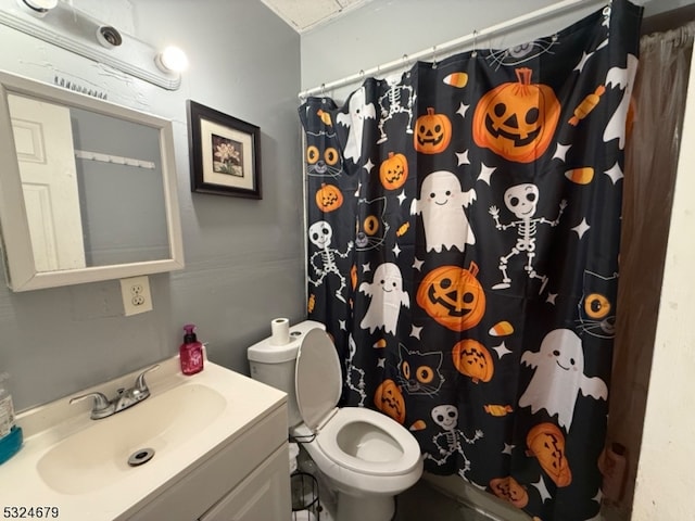 bathroom featuring walk in shower, vanity, and toilet