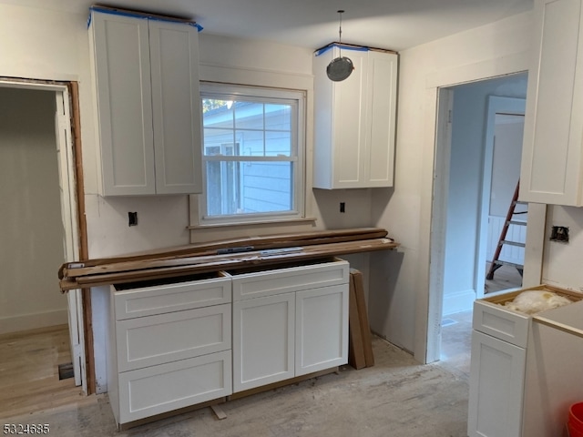 kitchen featuring white cabinets, pendant lighting, and light hardwood / wood-style floors