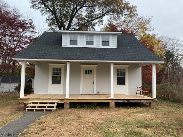 view of front of house featuring covered porch, a shed, and a front yard