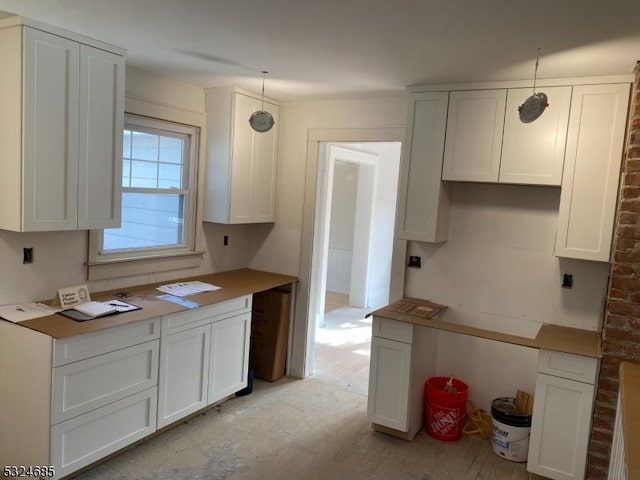 kitchen with white cabinets and hanging light fixtures