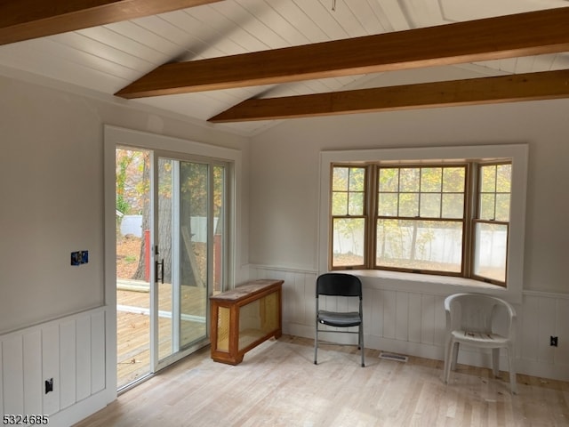 unfurnished room with lofted ceiling with beams and light hardwood / wood-style floors