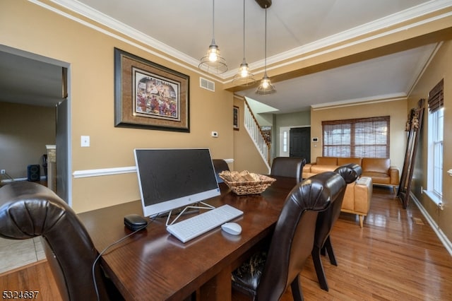 dining space with hardwood / wood-style flooring and ornamental molding