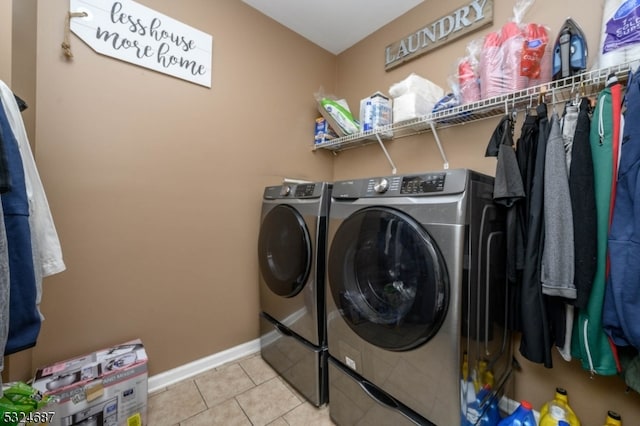 washroom with light tile patterned floors and washing machine and dryer