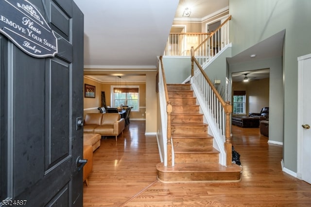 entryway with hardwood / wood-style flooring, ceiling fan, and ornamental molding