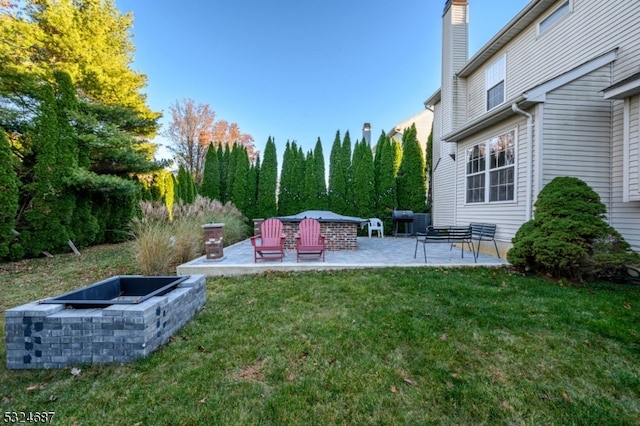 view of yard featuring a patio and an outdoor fire pit