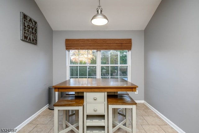 dining space featuring light tile patterned floors and lofted ceiling