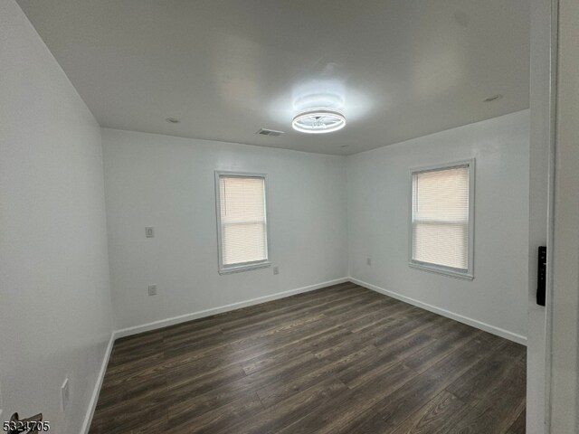 spare room with dark hardwood / wood-style flooring