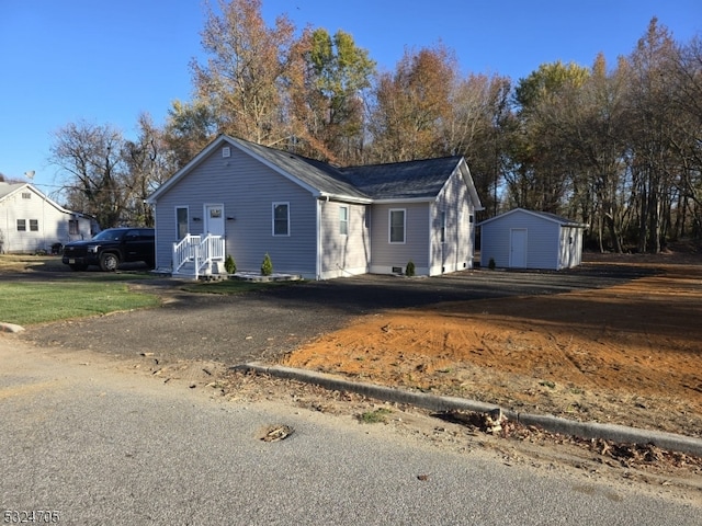 view of front of property featuring a storage shed