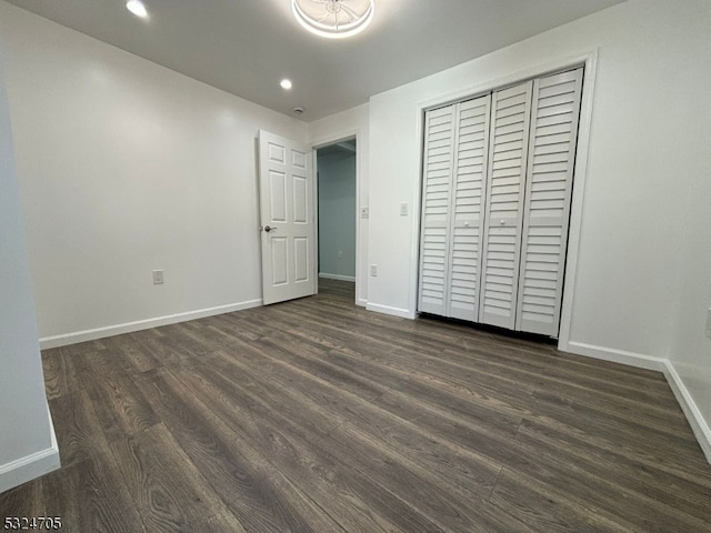 unfurnished bedroom with dark hardwood / wood-style floors and a closet