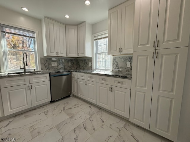 kitchen featuring stainless steel dishwasher, a healthy amount of sunlight, white cabinets, and sink