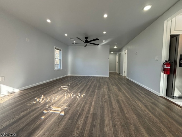 unfurnished living room featuring dark hardwood / wood-style flooring and ceiling fan