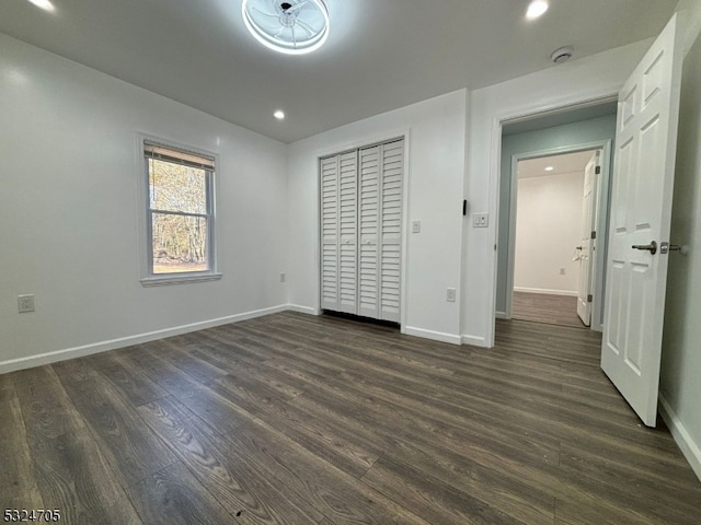 unfurnished bedroom featuring dark hardwood / wood-style floors and a closet