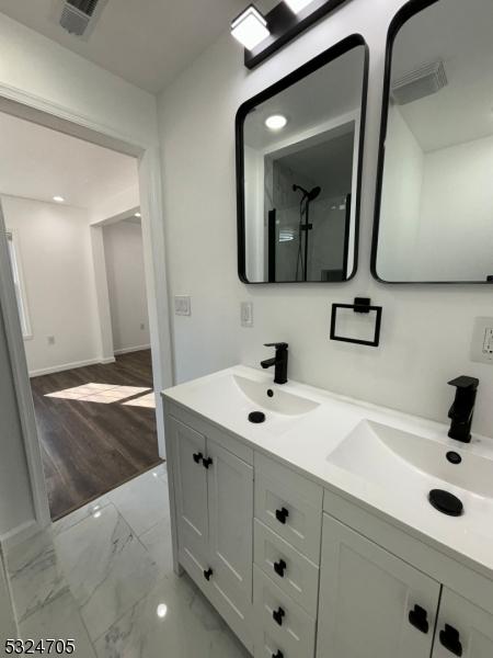 111 E Del A Vue Ave, Carneys Point Twp, NJ 08069 - bathroom with double vanity, marble finish flooring, a shower, and baseboards