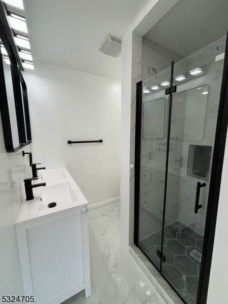 bathroom with vanity and a shower with door