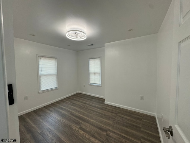 unfurnished room with dark wood-type flooring