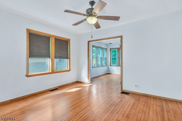 empty room with ceiling fan and light hardwood / wood-style floors