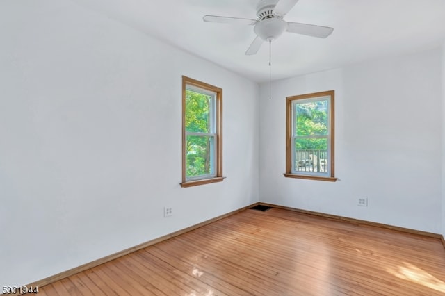 spare room with light hardwood / wood-style floors, plenty of natural light, and ceiling fan