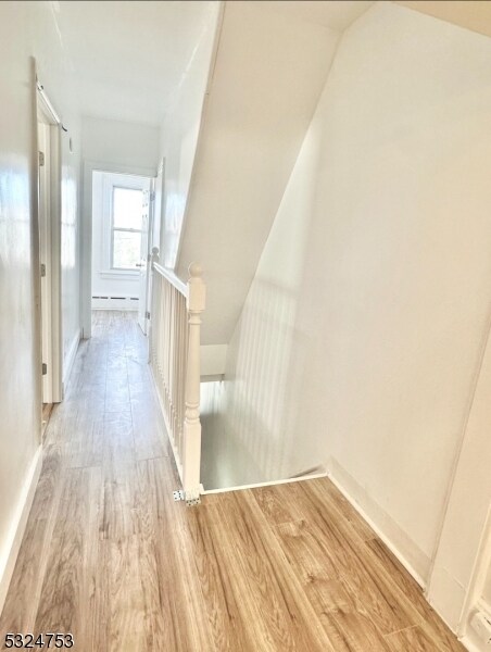 staircase with hardwood / wood-style floors and lofted ceiling