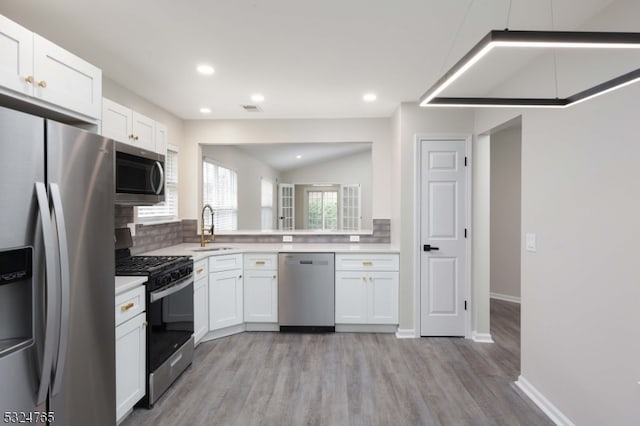 kitchen with white cabinets, stainless steel appliances, light hardwood / wood-style floors, and sink