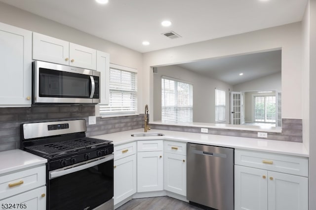 kitchen featuring white cabinets, decorative backsplash, and stainless steel appliances