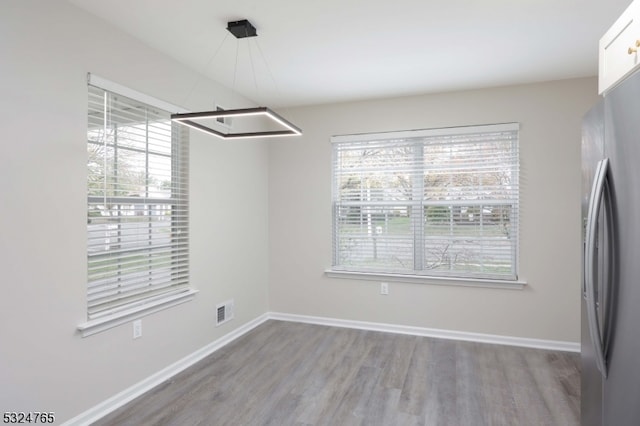 unfurnished dining area featuring wood-type flooring