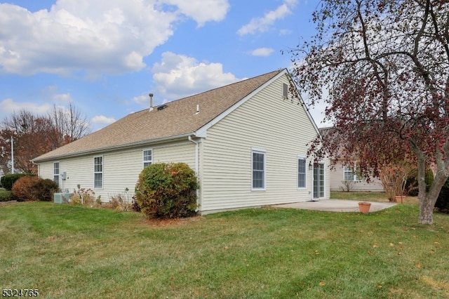 view of side of property featuring a lawn and a patio