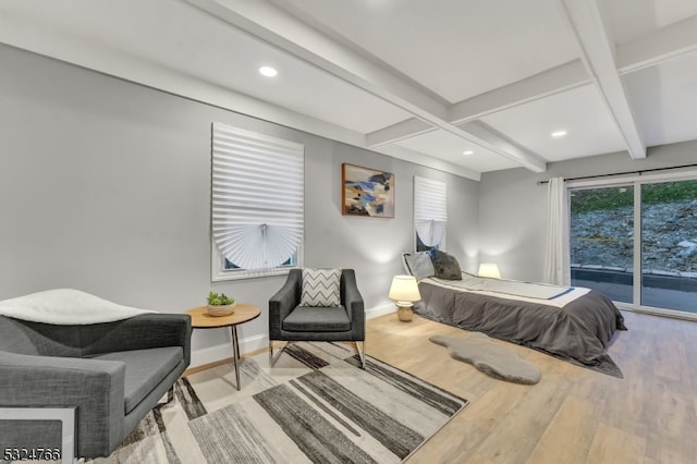 bedroom with beamed ceiling, access to exterior, and light hardwood / wood-style flooring