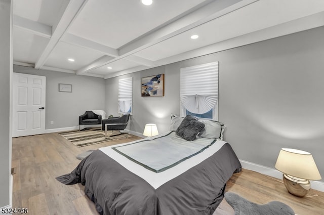 bedroom with beam ceiling and light wood-type flooring