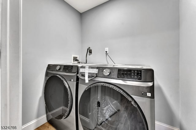 laundry room featuring wood-type flooring and separate washer and dryer