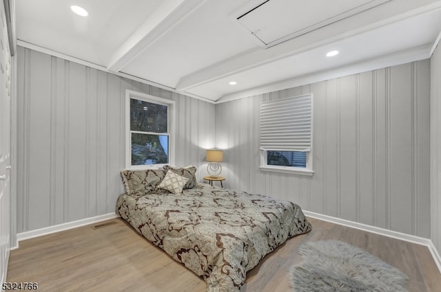 bedroom featuring beam ceiling and light hardwood / wood-style flooring