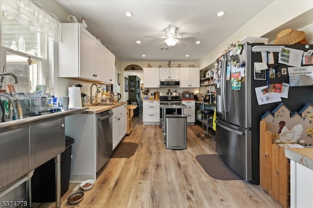 kitchen featuring ceiling fan, white cabinetry, sink, light wood-type flooring, and appliances with stainless steel finishes