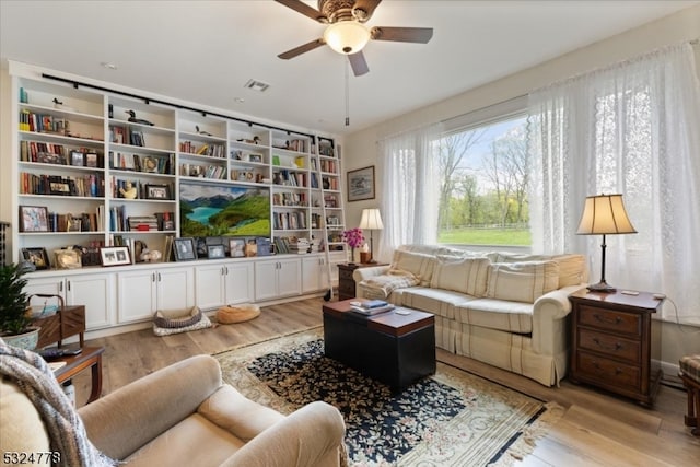 living room with ceiling fan and light hardwood / wood-style floors