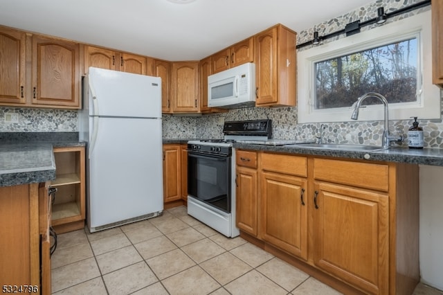 kitchen featuring decorative backsplash, sink, light tile patterned floors, and white appliances