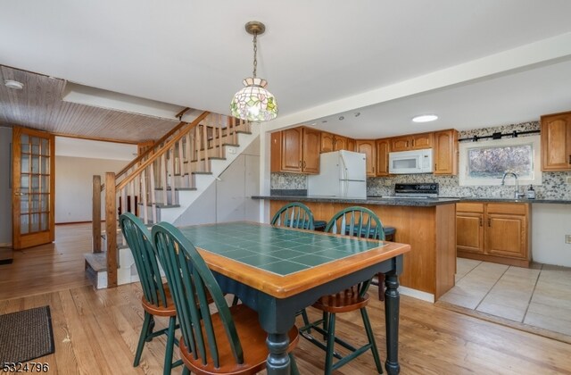 dining space with light hardwood / wood-style flooring and sink