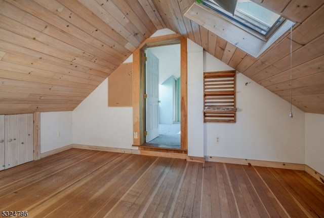 additional living space with hardwood / wood-style floors, lofted ceiling with skylight, and wooden ceiling