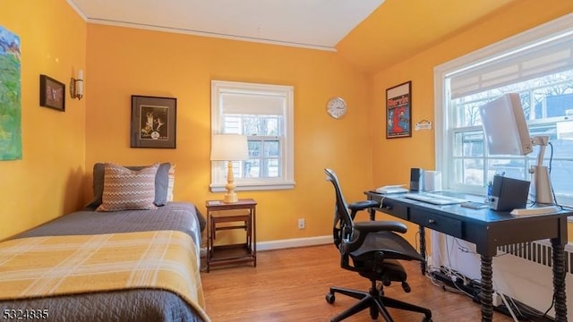 bedroom with baseboards, multiple windows, and light wood-style floors