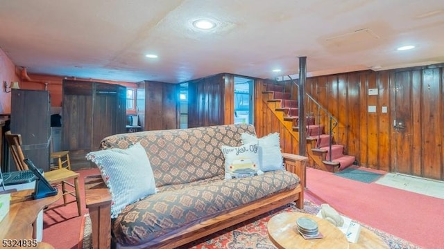 living area with recessed lighting, wood walls, and stairs