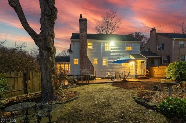 back of house featuring a chimney and fence