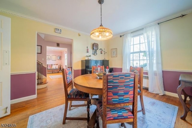 dining area with baseboards, stairs, radiator, light wood finished floors, and crown molding