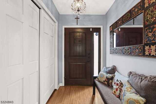 foyer with an inviting chandelier, a healthy amount of sunlight, and hardwood / wood-style flooring