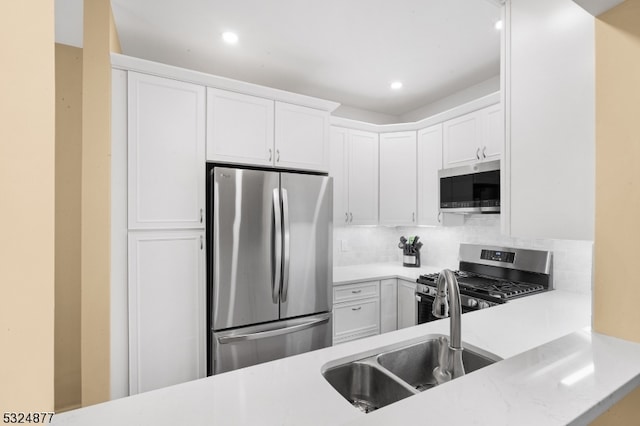 kitchen with decorative backsplash, sink, white cabinetry, and stainless steel appliances