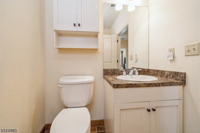 bathroom featuring tile patterned floors, vanity, and toilet