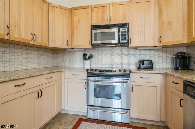 kitchen with backsplash, light brown cabinets, light stone counters, and stainless steel appliances