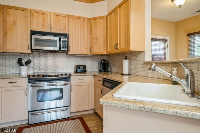 kitchen with decorative backsplash, light brown cabinets, sink, and appliances with stainless steel finishes