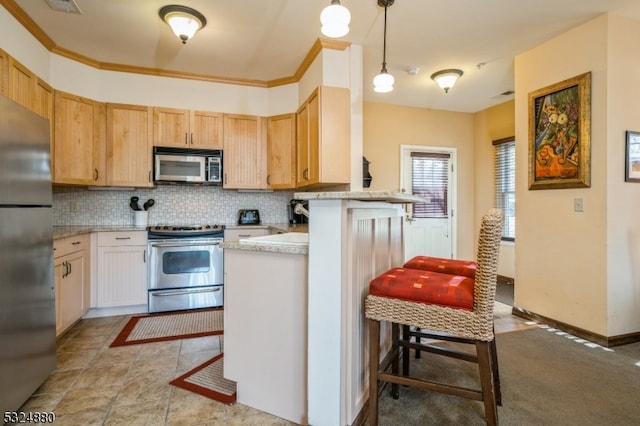 kitchen featuring a breakfast bar area, kitchen peninsula, pendant lighting, and stainless steel appliances