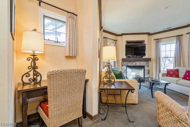 living room with a fireplace, carpet floors, crown molding, and a healthy amount of sunlight