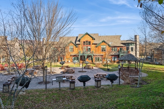 surrounding community featuring a gazebo, a patio area, and a lawn