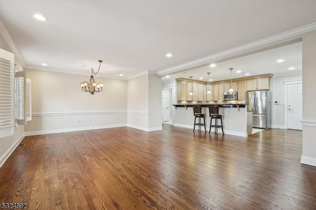 unfurnished living room featuring dark wood-style flooring, recessed lighting, an inviting chandelier, ornamental molding, and baseboards