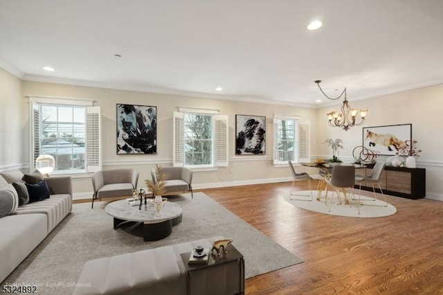 living room featuring recessed lighting, an inviting chandelier, ornamental molding, wood finished floors, and baseboards